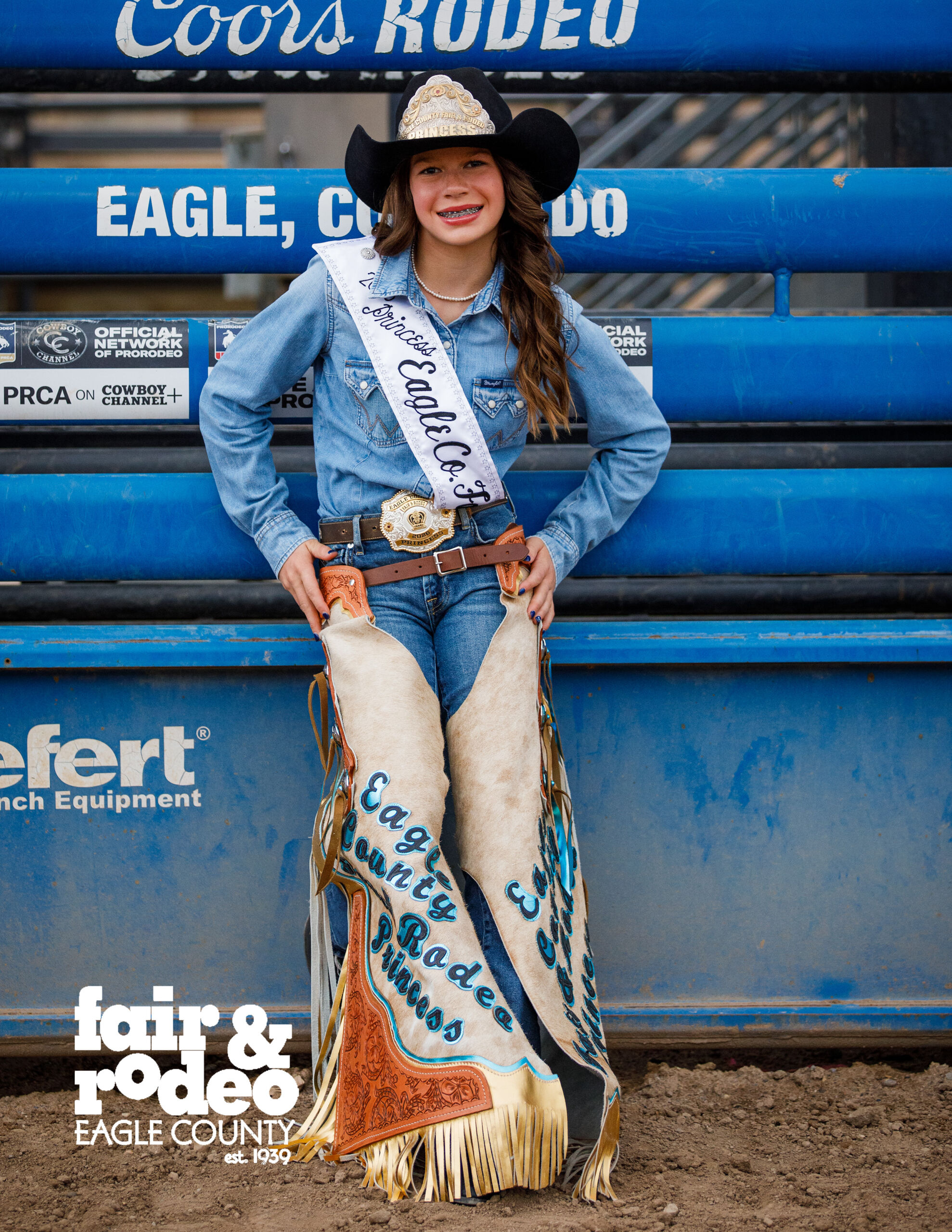Rodeo Princess standing in front of a fence